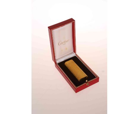 A CARTIER YELLOW METAL LIGHTER, the textured case with rounded sides, in a Cartier box. 7cm