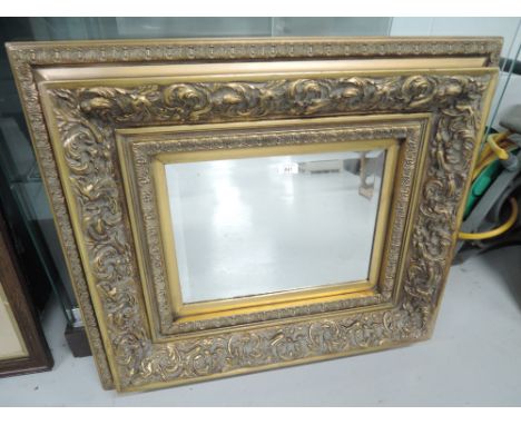 A vintage hall way mirror with elaborate gilt and plaster frame with bevel edged glass