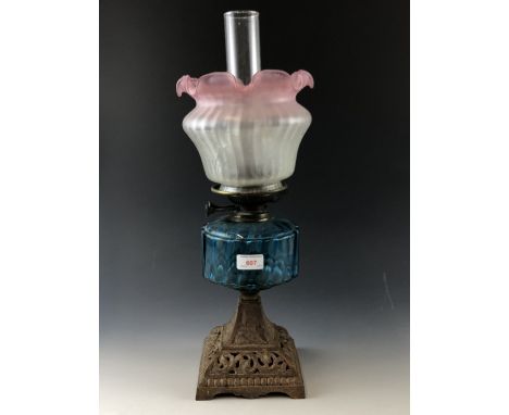 A Victorian oil lamp, having cast pyramidal base, vivid blue glass reservoir and Art Nouveau etched achromatizing pink glass 