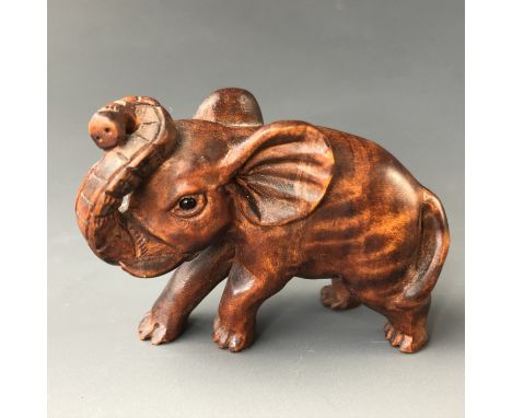 A Japanese carved wooden netsuke modelled as an elephant