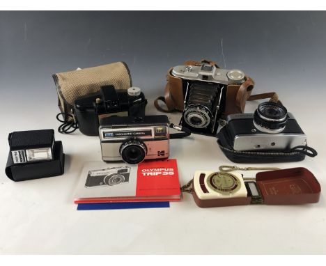 Vintage cameras including an AGFA Jsolette, an Olympus Trip 35 with instruction booklet, a Kodak "Brownie" 127, and a Kodak 1