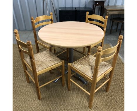 A contemporary light beech dining table, 90 cm diameter, and four pine dining chairs with rush seats 
