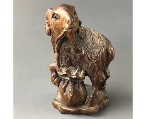 A Japanese carved wood netsuke modelled as a goat