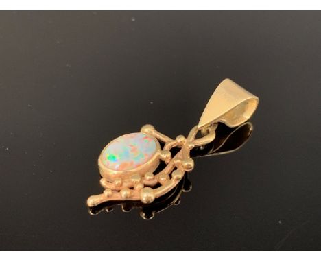 A 9ct gold and opal pendant, the opal cabochon of approximately .75ct, bezel set and suspended adjacent a stylised budding bo