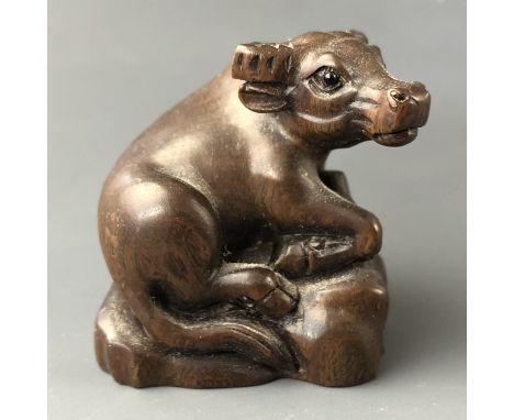 A Japanese carved wood netsuke modelled as water buffalo  