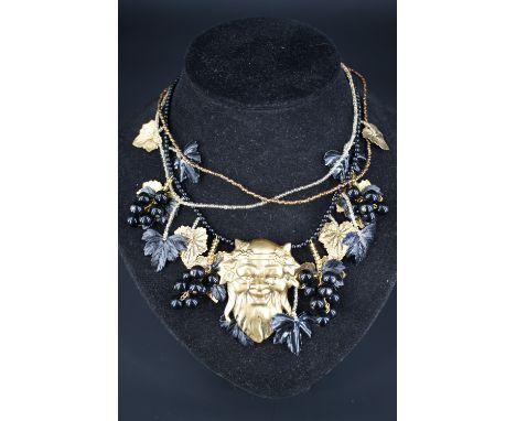 A vintage gilt-metal and Lucite necklace incorporating the mask of Bacchus and fruiting vines, suspended from three beaded ne