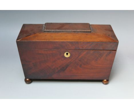 A 19TH CENTURY MAHOGANY TEA CADDY, of sarcophagus outline, the hinged lid opening to a twin lidded compartment, minus origina