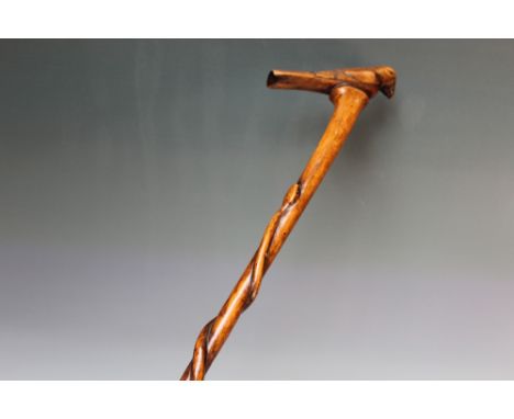 A FOLK ART WALKING STICK WITH HANDLE IN THE FORM OF A PERCHED BIRD,  the cane being carved with a serpent ascending the stick