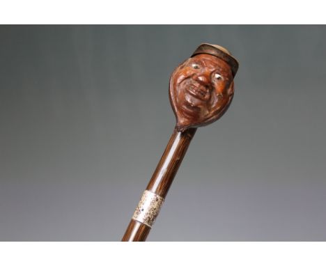 A HALLMARKED SILVER BANDED NOVELTY WALKING STICK WITH HANDLE IN THE FORM OF A COMICAL JOCKEY, H 84 cm