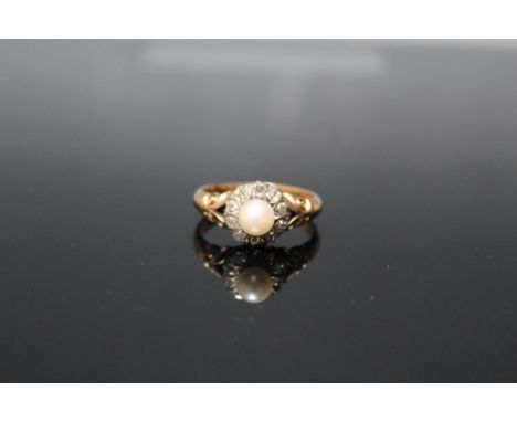 AN 18 CARAT GOLD PEARL AND DIAMOND CLUSTER RING,  having an 18 carat yellow gold fleur de lys shank and grain set head, ten o