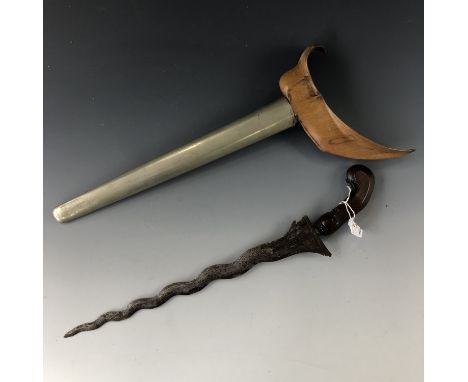 A Malayan kris / dagger, having carved hardwood grip, serpentine blade with characteristic pamor, and nickel-covered wooden s