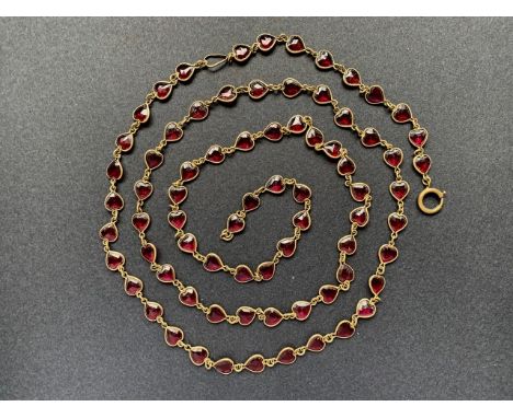 An Edwardian sautoir necklace with ruby paste hearts suspended within gilt-metal wire, with bolt-ring clasp, 130 cm