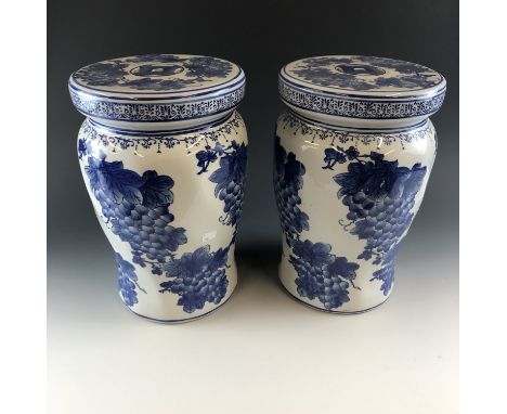 A pair of ceramic blue and white stools, decorated with a grape design