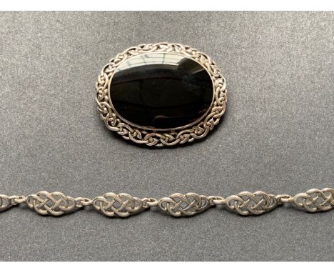 A contemporary white-metal (tests as silver) and onyx brooch, of Celtic influence, and a similar bracelet (stamped '925'), 26