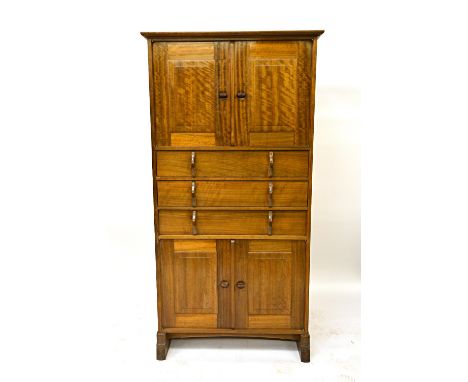 An Australian walnut tallboy by Peter Waals, 1930, the moulded projecting top and plain sides with visible mortise joints ove