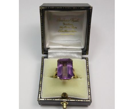 A modern 14ct gold and amethyst single stone ring, the cut-corner rectangular step-cut stone, claw set to a square section sh