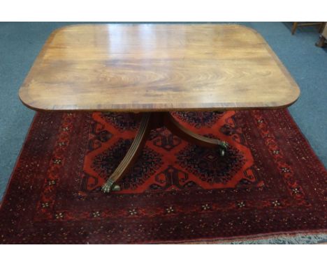 A Regency mahogany breakfast table, the rectangular rosewood crossbanded boxwood and ebony strung tilt-top, on a vase turned 