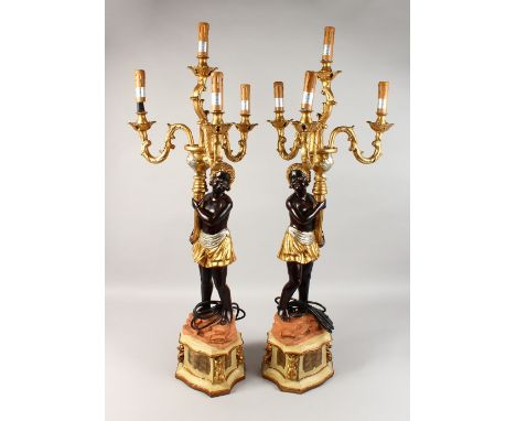 A PAIR OF BLACKAMOOR FOUR-LIGHT CANDELABRA, the stems as Blackamoor figures holding scrolling branches. 34ins high.