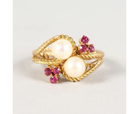 A GOLD RING, with crossover pearls and flower head.