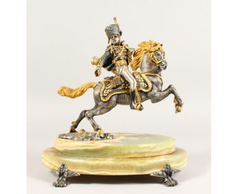 A LIMITED EDITION SILVER AND GILT METAL MODEL OF A HUSSAR ON HORSEBACK, mounted on an onyx base. 11.5ins high.