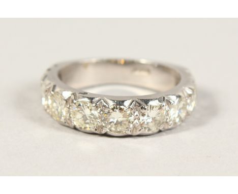 AN 18CT WHITE GOLD NINE STONE HALF HOOP DIAMOND RING.