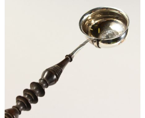 A SILVER TODDY LADLE, inset with a coin. 11ins long.