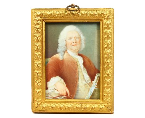 A GEORGIAN MINIATURE PORTRAIT OF A MAN, half-length with wig and holding papers. Signed.  4ins x 3ins.