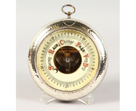 A CIRCULAR BAROMETER, 4.25ins diameter, in a hammered silver mounted wooden frame. Birmingham 1910.