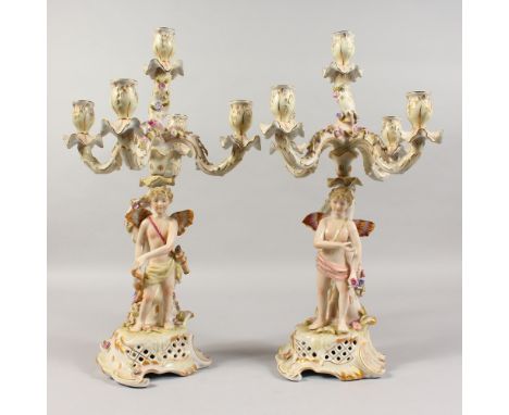 A PAIR OF DRESDEN DESIGN PORCELAIN FIVE-LIGHT CANDELABRA, with cupid supports. 17ins high.