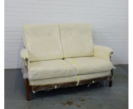 An Ercol 'Gina' two seater sofa, with cream upholstered arms, back and seat, on Golden Dawn supports, 100 x 153cm (please not