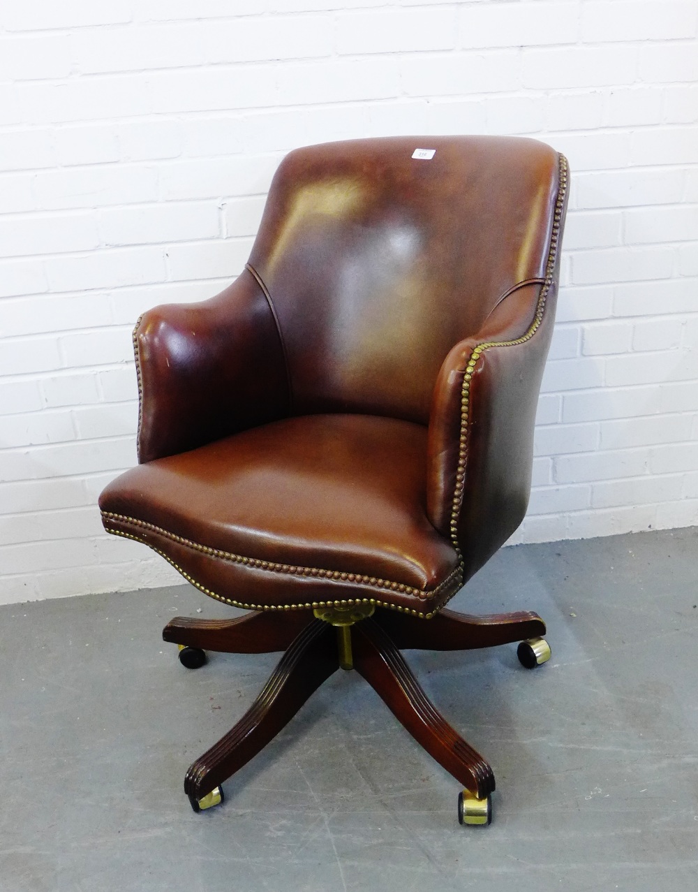 A brown leather captains style chair, 92 x 60cm