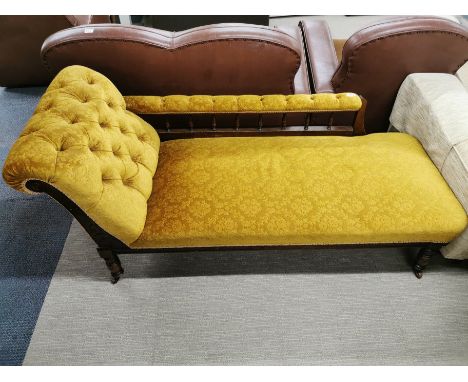 A carved mahogany and button backed, floral upholstered chaise longue on castors, L. 165cm. One castor missing.