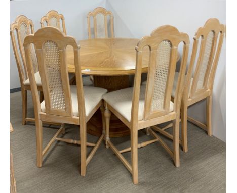 A handmade circular light oak pedestal dining table with extension leaf, dia. 136, leaf W. 65cm, together with a set of six b