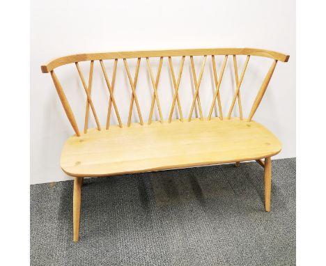 An Ercol light elm two seater spindle cross back settle. L. 112cm, H. 83cm.