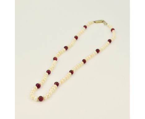 A cabochon ruby and pearl necklace with white metal clasp, L. 48cm. Minor damage to some rubies.
