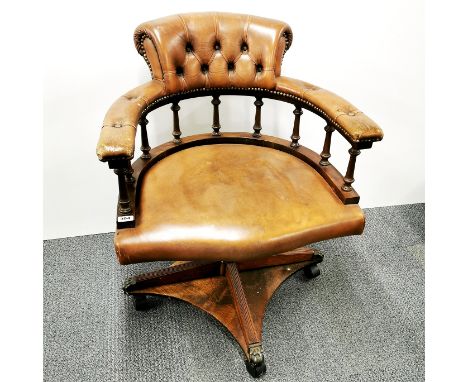 A leather button back revolving captain's chair. H. 92cm.