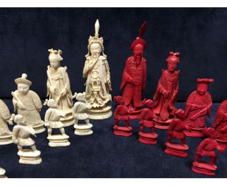 A Chinese red and white ivory part chess set, each piece carved as an appropriate figure, the pawns soldiers, the kings 9cm (