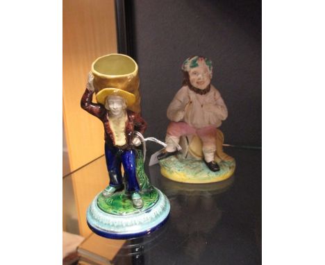 A mid 19th century Royal Worcester coalman match/taper holder, together with an early 19th century Staffordshire seated Bacch