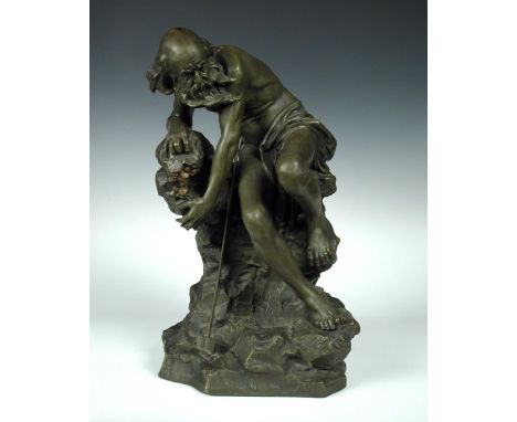 A bronzed spelter figure depicting 'The Miser' signed 'Toretay', circa 1900, the bearded man seated by his spade, his hand to