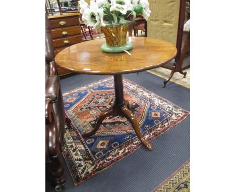 A George III mahogany flip top table, the circular top on turned tapered column to tripod base with pointed pad feet, 79cm di