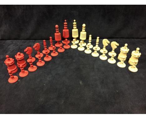 A 19th century Indian bone chess set, the red and white pieces ring turned, the kings 9.5cm (3.75 in) high  A red castle has 
