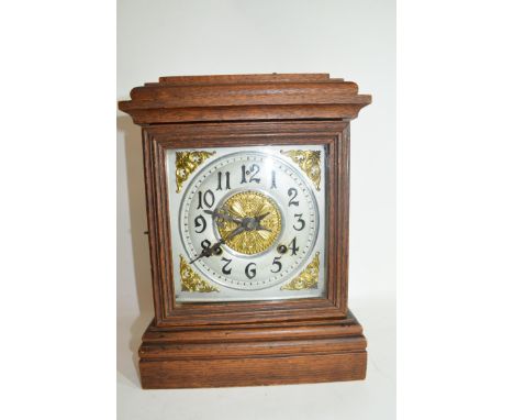 Early 20th century mantel clock, pressed metal dial to a brass movement striking on a coiled gong set in an oak case with ste
