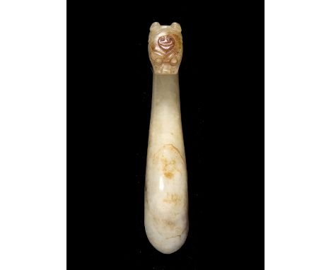 A Chinese Ming style white and brown infused jade belt buckle 18th/19th Century with dragon hook overlooking a tear shaped ro