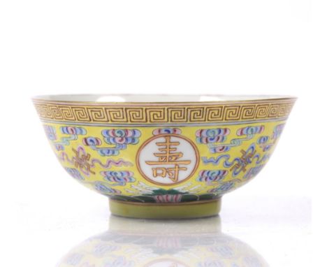 A Chinese yellow enamel longevity bowl decorated in coloured enamels,with four gilt roundels bearing symbolic characters on a