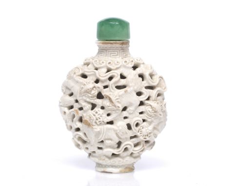 A Chinese Jingdezhen white glazed porcelain oviform snuff bottle decorated with dogs of fo, ribbons and with ruyi border, 7.2