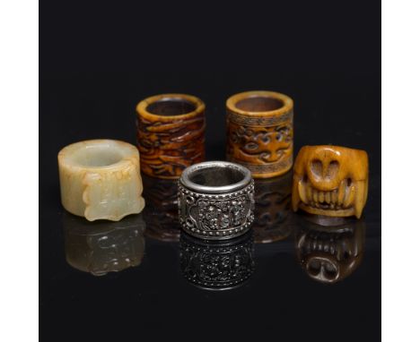 A Chinese silver metal archers ring late 19th Century three Tibetan carved yak horn archer's rings and a Chinese jade archer'
