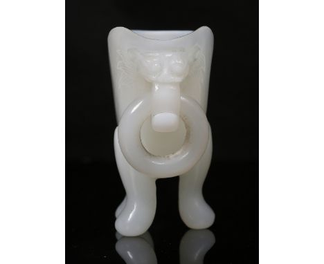 A Beijing opaline white glass libation cup 19th Century the flattened body on tripod feet with single handle and a Dog of Fo 