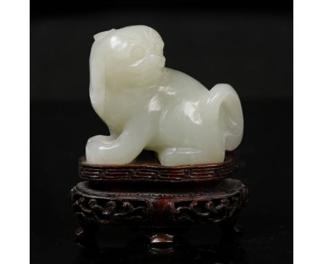 A Chinese pale green jade 19th Century seated Pekinese looking over left shoulder, pierced and carved fitted stand Provenance