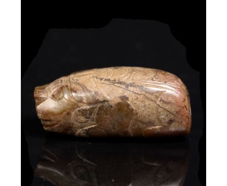 A Chinese Han style rust and green jade amulet or bead carved as a recumbent pig, upon its back a rug carved with a linear mo