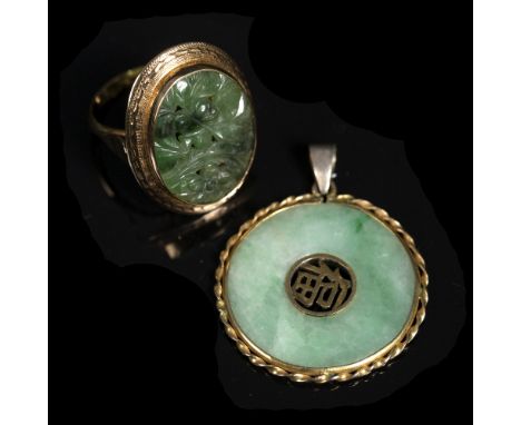 A Chinese jade annular pendant with central pierced motif and rope twist border and a green hardstone panel ring, yellow prec